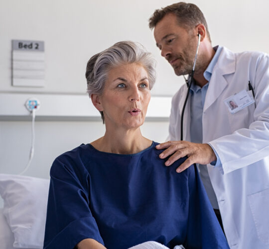 medico escuchando los pulmones de una paciente