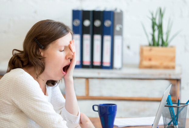 Mujer bostezando en la oficina