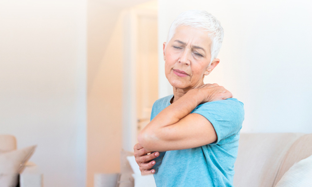 mujer de la tercera edad con gesto de dolor en la espalda