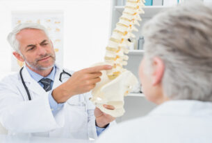 Doctor explicando a paciente con un modelo 3d de espina dorsal