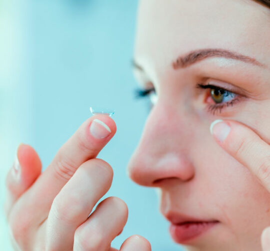 mujer vista de perfil colocando lente de contacto