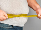 persona obesa midiendo su cintura