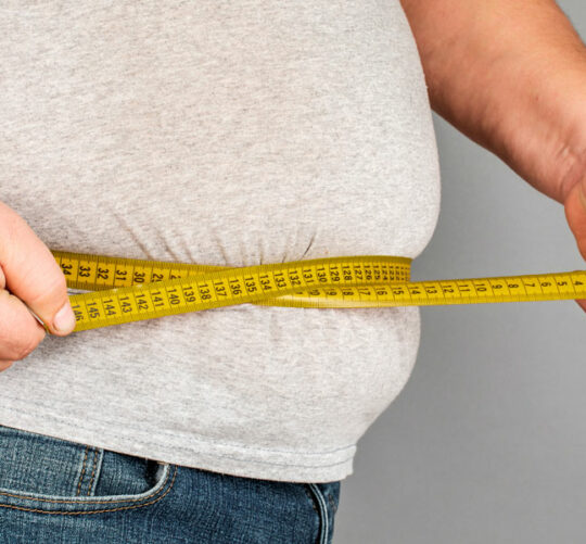 persona obesa midiendo su cintura