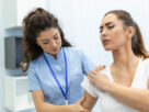 Doctora revisando hombro de paciente mujer