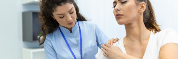Doctora revisando hombro de paciente mujer