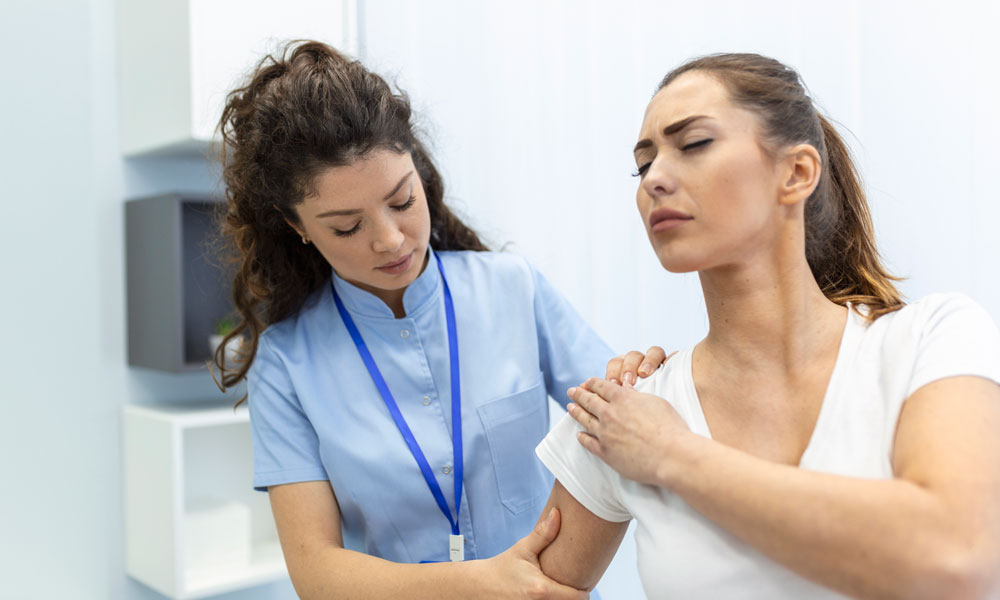 Doctora revisando hombro de paciente mujer