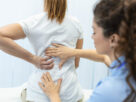 doctora revisando columna vertebral de paciente femenina