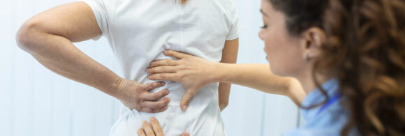 doctora revisando columna vertebral de paciente femenina