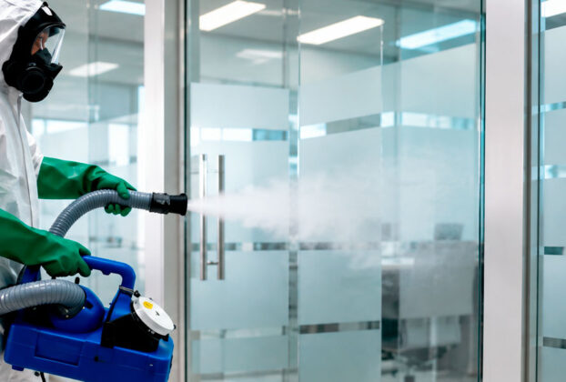 Hombre esterilizando oficina con ozono