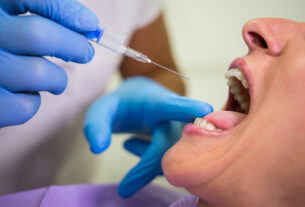 Dentista inyectando a paciente