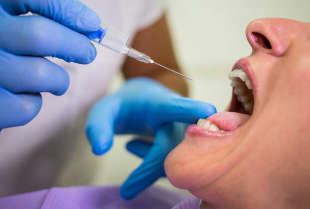 Dentista inyectando a paciente